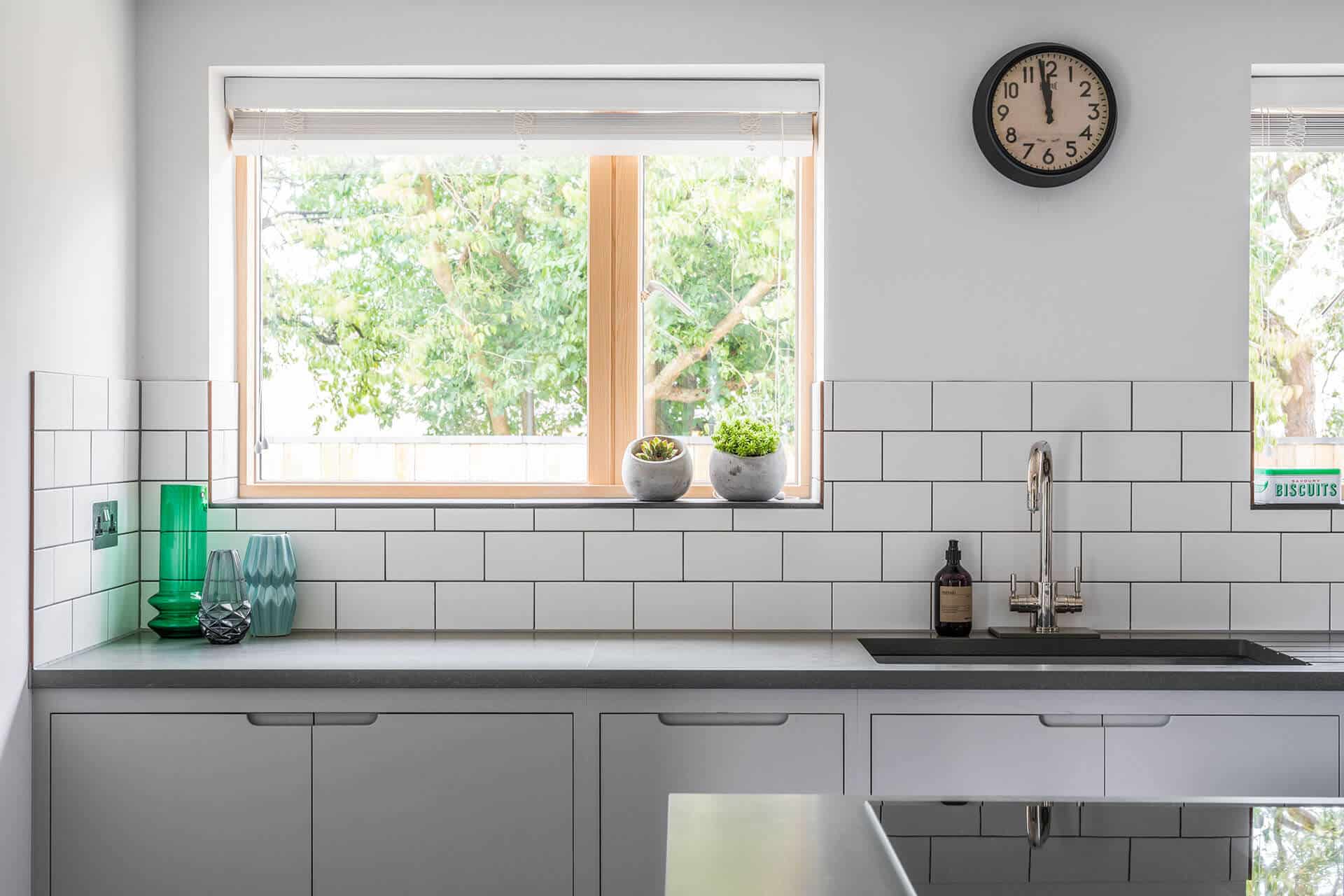 Contemporary grey industrial kitchen with white metro tile splashback