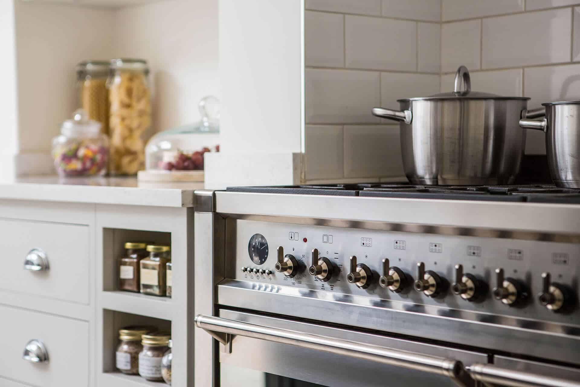Open plan white Shaker kitchen with Smeg range cooker and quartz worktop