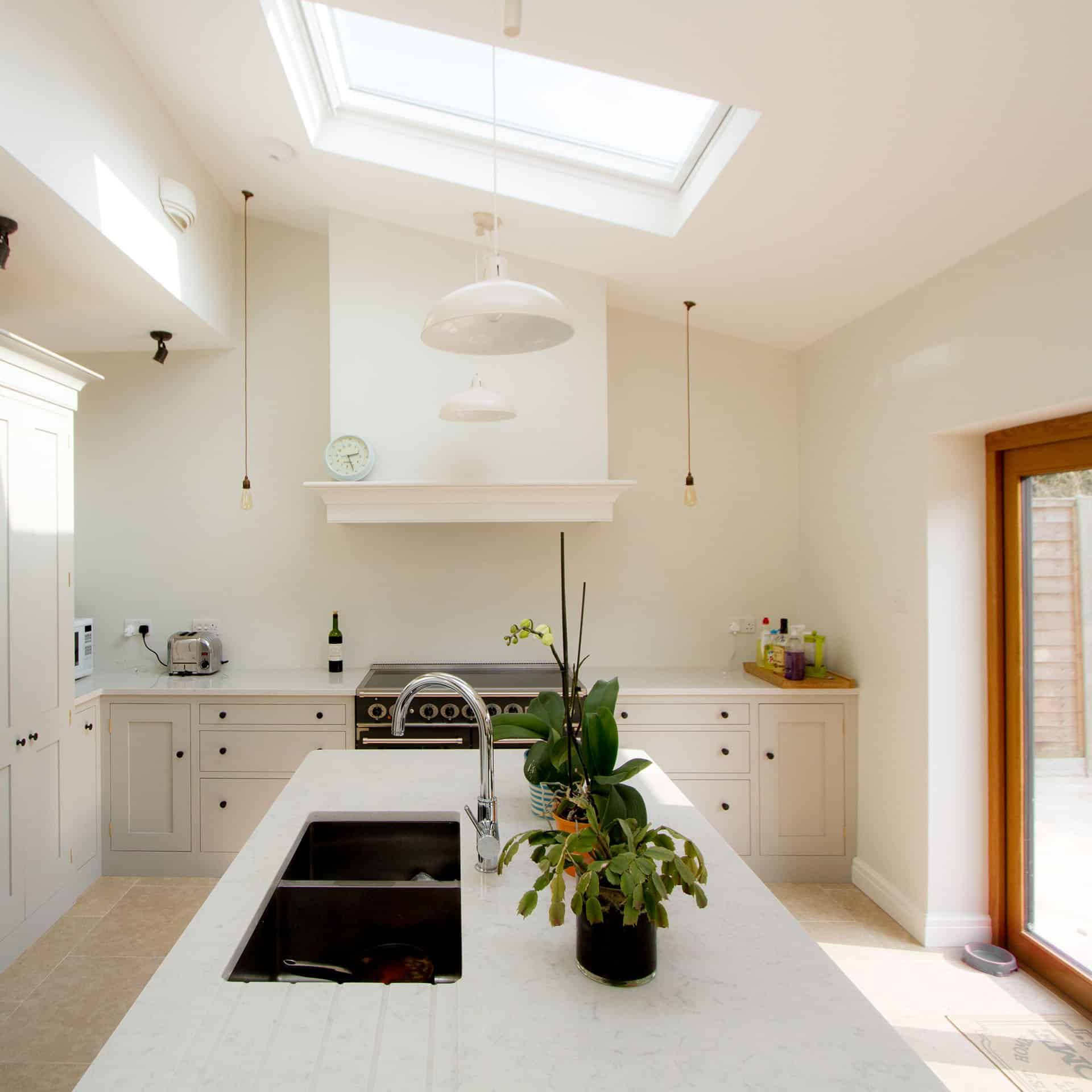 Stunning Shaker Kitchen with large kitchen island and white marble worktops and plants