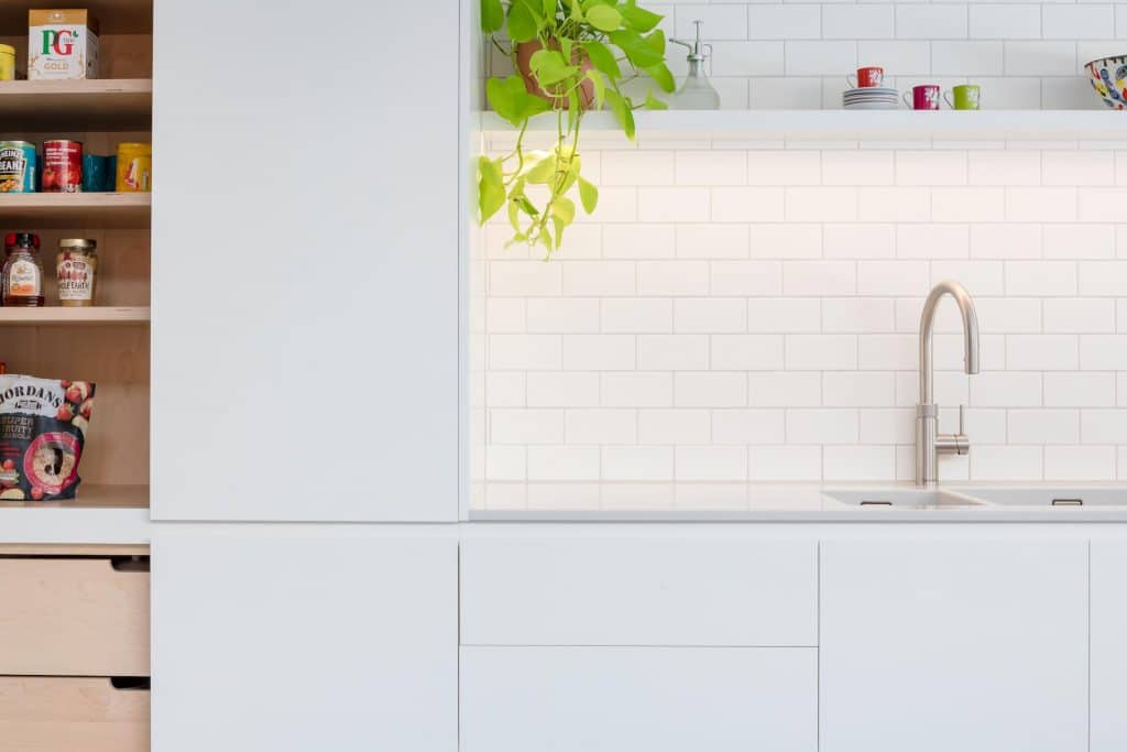 Contemporary White Kitchen with white corian worktop and quooker tap - Sustainable Kitchens
