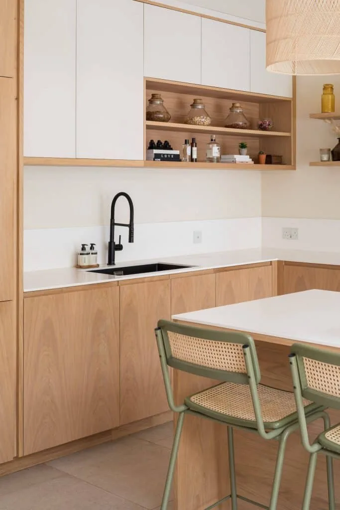 a natural wood kitchen with white accents and black tap