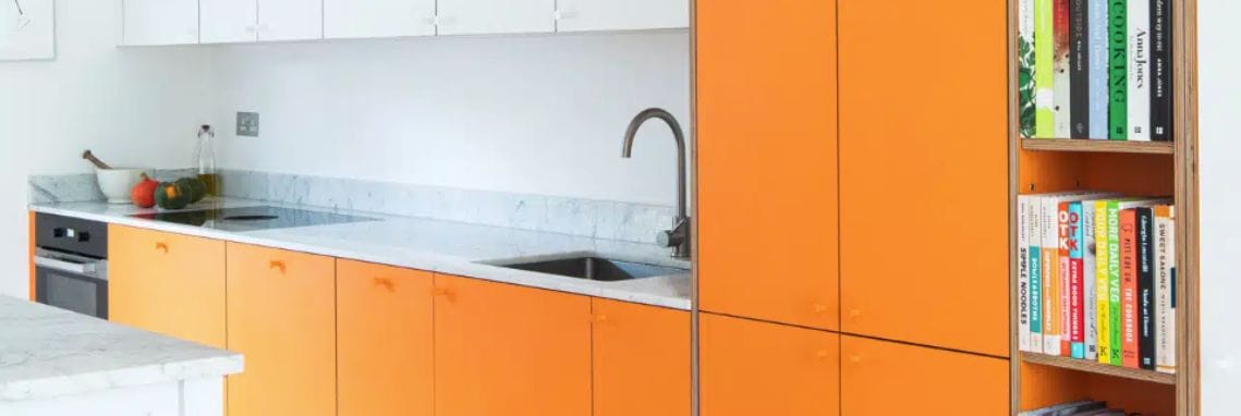Contemporary bespoke kitchen in burnt orange with overlay cabinets and minimalist design