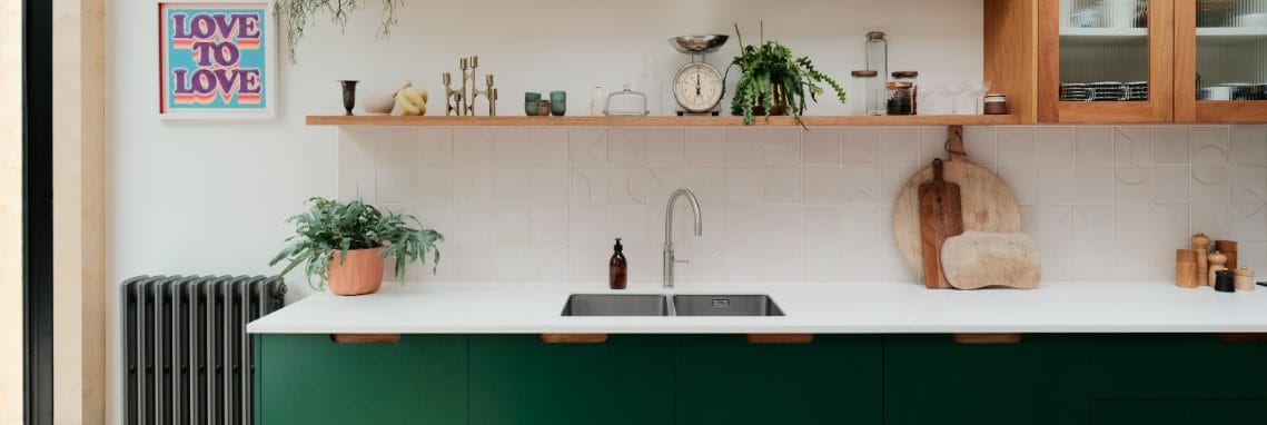 Bespoke kitchen with green in-frame cabinets and oak details