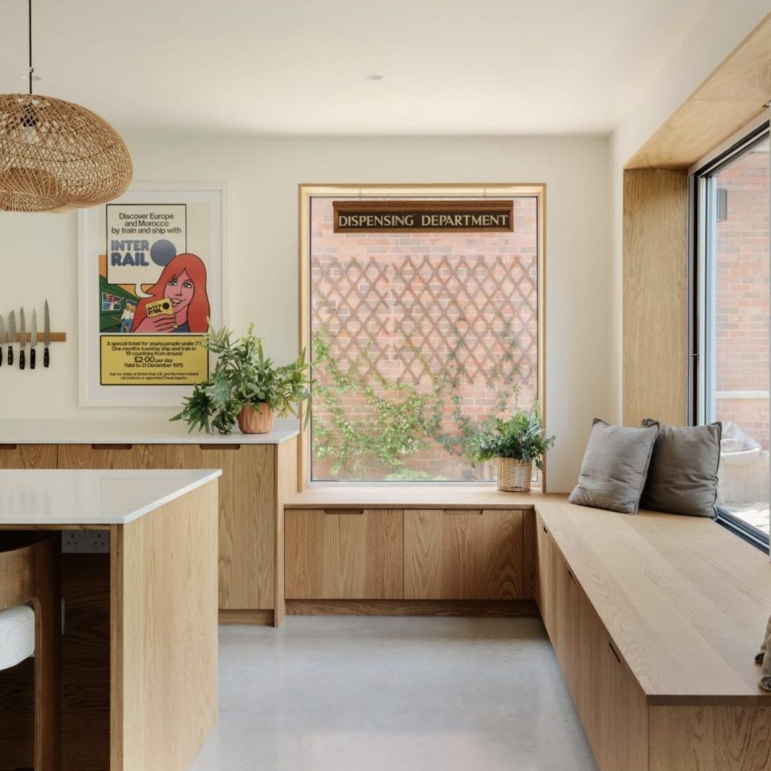 Oak and Concrete Kitchen with integrated bench seat and large picture window, featuring Caesarstone Calacatta Nuvo worktops and oak scoop-handle cabinetry.